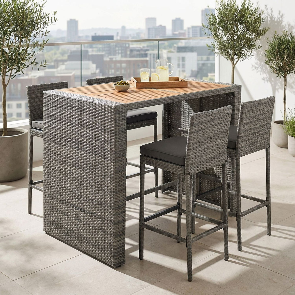 Bar table with a lemonade tray and two stools pulled out on a rooftop terrace