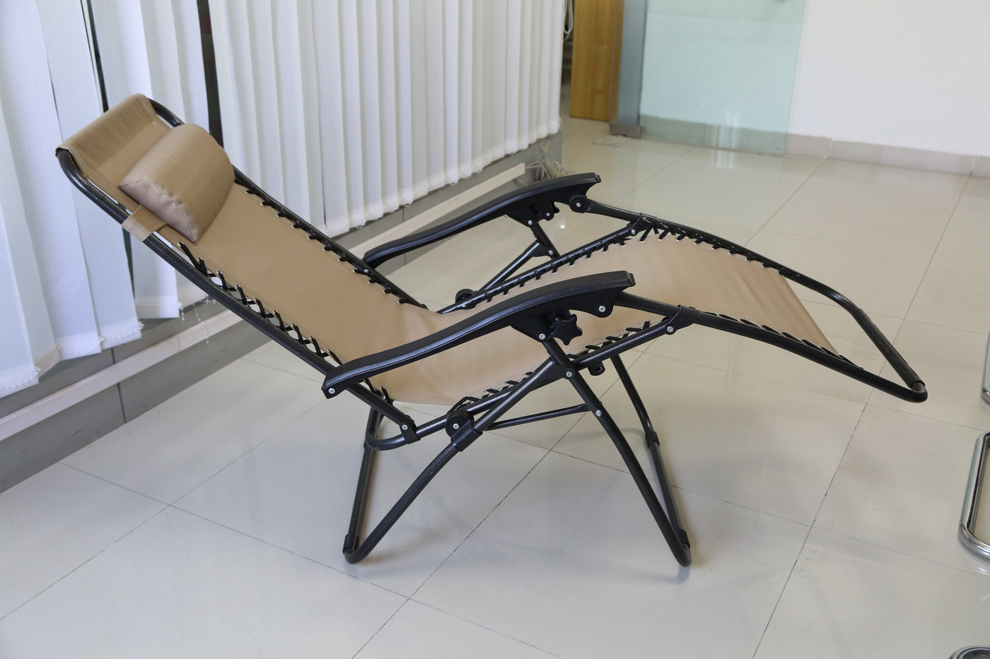 Zero Gravity Lounge Chair with Dual Side Tray in tan fabric, reclined for neck and back relief.