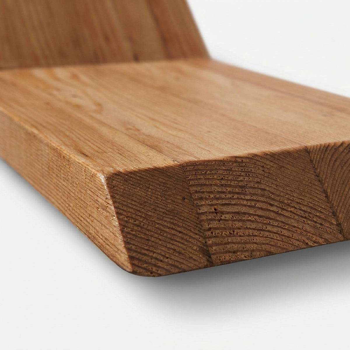 Chamfered tray end of a reclaimed wood shelf showing end-grain growth rings (close-up detail)