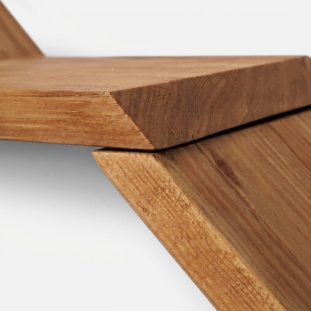 Step seam where one reclaimed wood shelf rests on the riser of the shelf below (close-up detail)